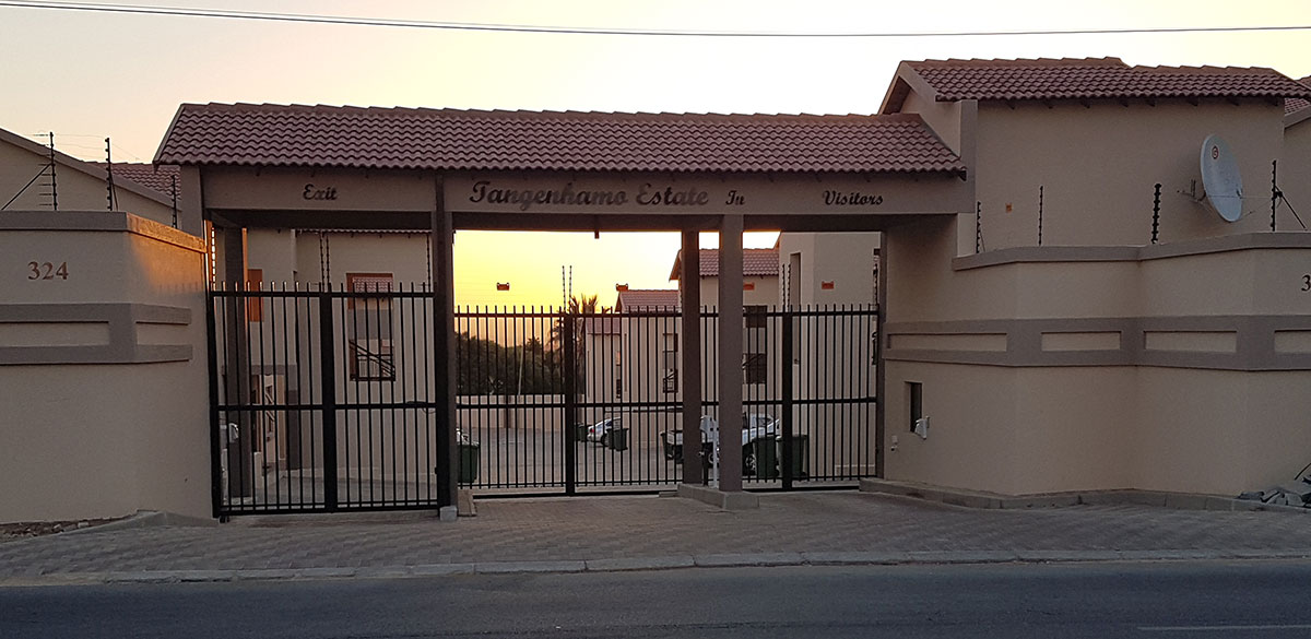 Entrance gate to a Tangenhamo Properties estate at golden hour.